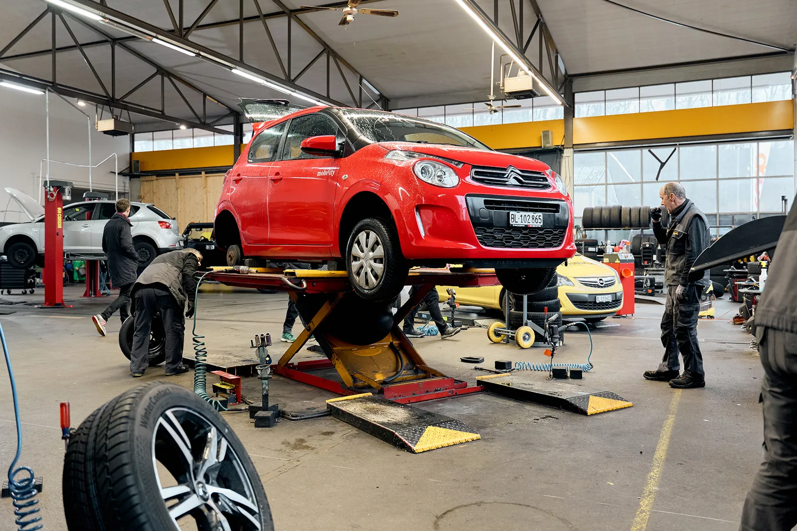 Mechanic fitting tyre to Mobility car.