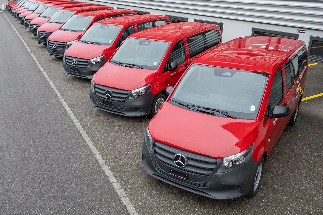 Row of red Mobility vans in the car park as part of a car-sharing vehicle fleet.