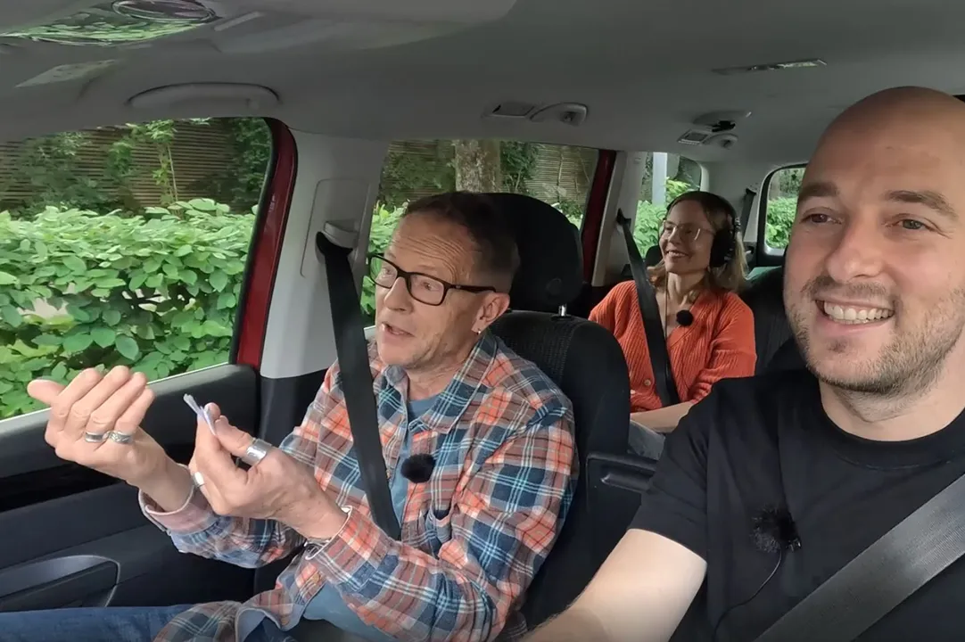 Three people drive together in a Mobility sharing car and chat during the journey.