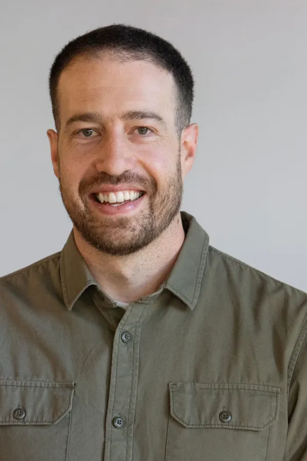 Luca Borra smiling at the camera against a neutral background.