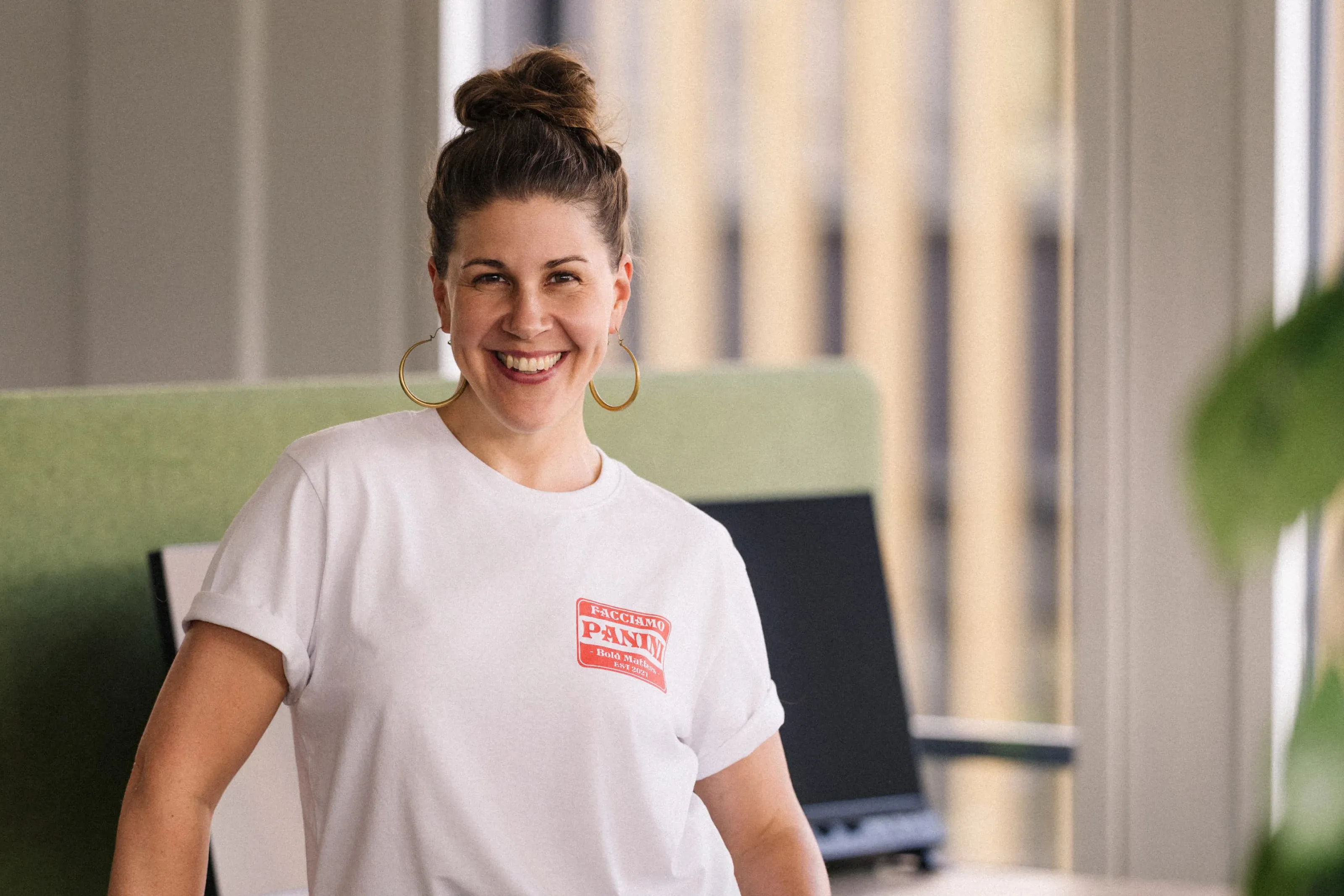 Noëlle Fischer smiling in a modern office and looking warmly at the camera.